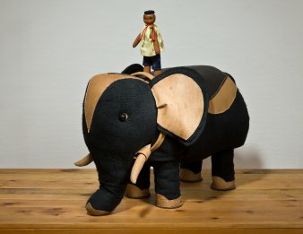 Spielzeug-Mensch auf einem Spielzeug-Elefanten