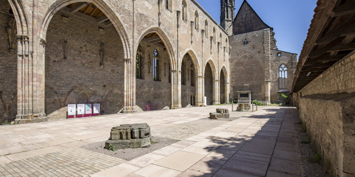 Foto: In unmittelbarer Nähe der Brücke, die die Schlösserstraße über den Breitstrom führt, steht die 1944 zum großen Teil zerstörte Barfüßerkirche. Noch in ihren Resten ist sie ein großartiges Beispiel deutscher Bettelordensbaukunst des 14. und 15. Jahrhunderts. © Stadtverwaltung Erfurt / V. Gürtler Kirchenruine unter blauem Himmel