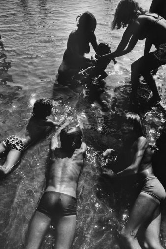 Im Wasser liegende und spielende Menschen