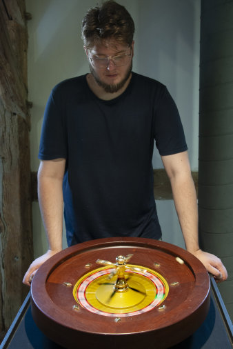 Ein Mann steht neben einem Roulette-Spiel