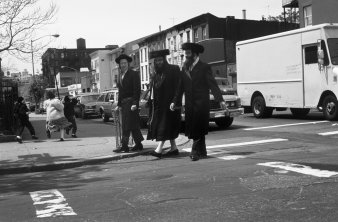 Drei Männer überqueren eine Straße