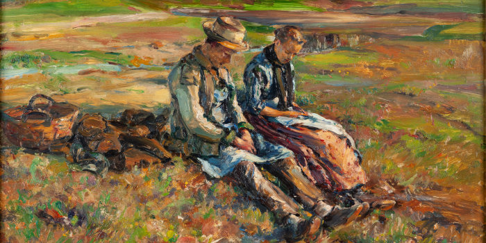Zwei Menschen sitzen auf einem Feld.