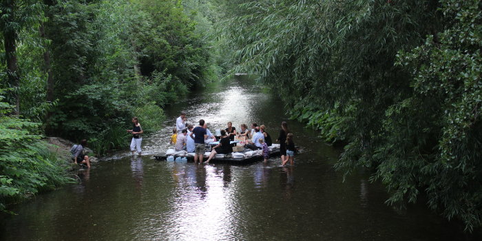Personen auf einer Plattform im Fluss