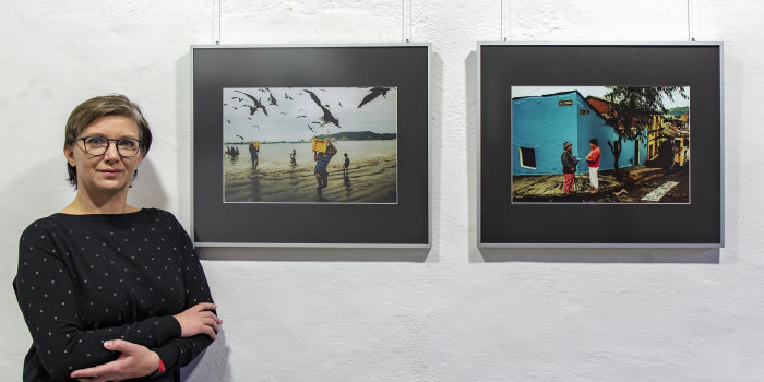 Eine Frau steht neben zwei Fotografien