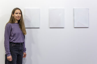Eine Frau steht neben weißen Kunstwerken