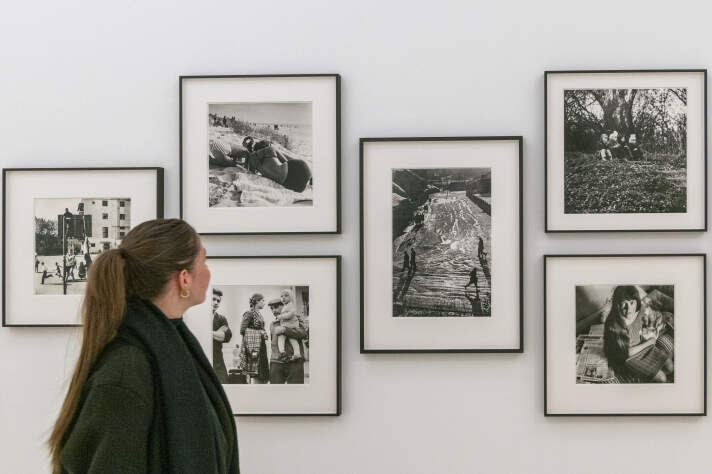 Kunstausstellung eröffnet: Eine Frau betrachtet Schwarz-Weiß-Fotos an einer Wand. 