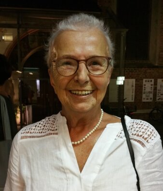 Eine ältere Dame lächelt in die Kamera