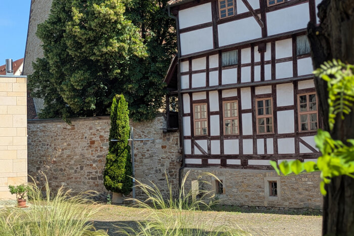 Mittelalterliches Fachwerkhaus mit gepflasterten Hof und etwas Grün