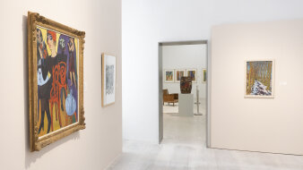 Ein Ausstellungsraum mit Gemälden an den Wänden