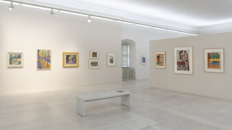Ein Ausstellungsraum mit verschiedenen Gemälden an den Wänden