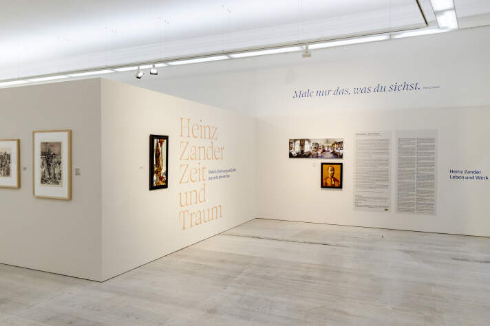Eingangsereich einer Ausstellung mit einzelnen Gemälden und Text