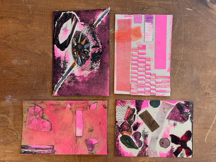 Bunte Druckplatten in Pinktönen auf einem Holzuntergrund liegend