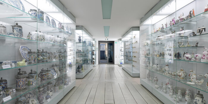 Ein heller Raum mit Vitrinen auf beiden Seiten in denen Porzellanobjekte stehen