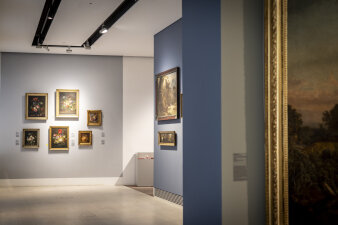 Ausstellungsraum mit Gemälden an verschiedenfarbigen Wänden