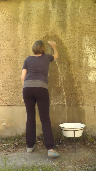 Eine Frau putzt eine Wand