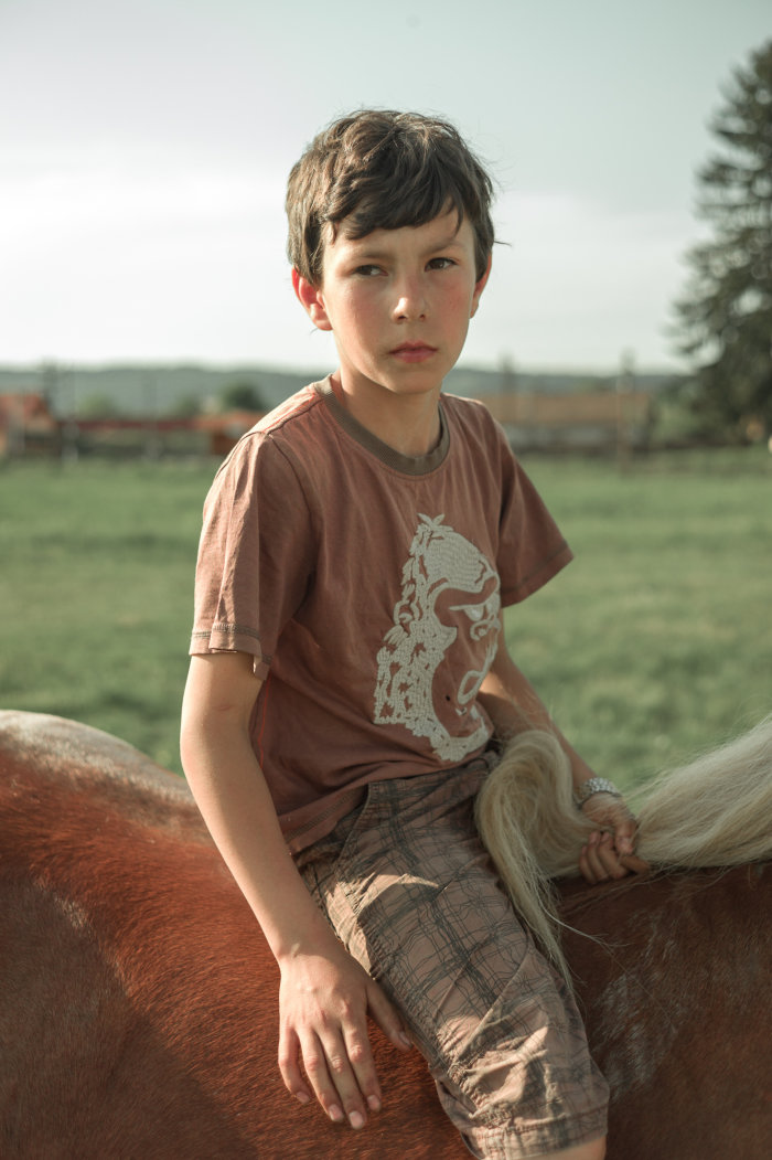 Ein Junge sitzt auf einem Pferd
