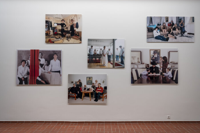 Blick auf eine Wand mit verschiedenen Fotografien von Familien