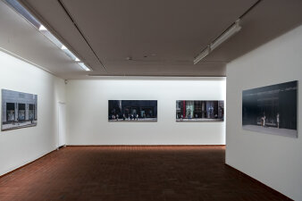 Blick in einen Ausstellungsraum mit Fotografien an der Wand