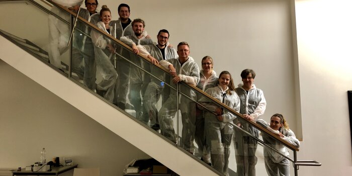 Menschen in weißen Anzügen auf einer Treppe stehend