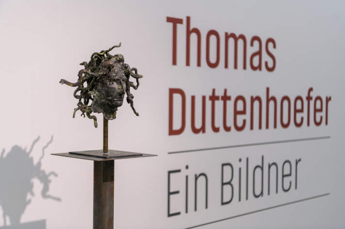 Skulptur vor einer Wand, an der "Thomas Duttenhoefer. Ein Bildner" steht
