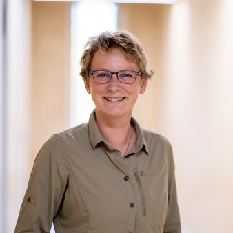 Portrait einer Frau mit Brille im braunen Hemd