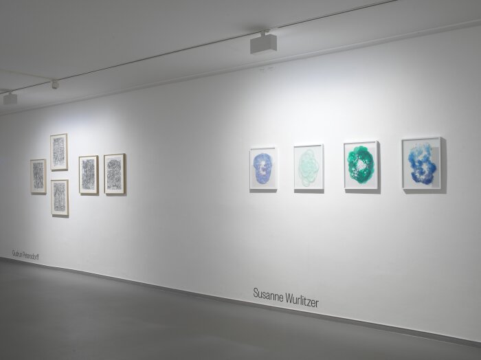 Ein offener heller Raum mit verschiedenen Gemälden an der Wand