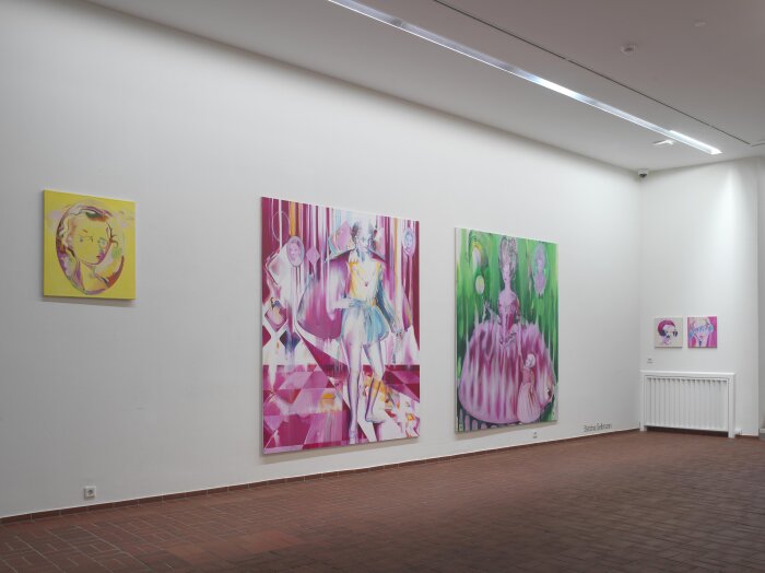 Ein offener heller Raum mit verschiedenen Gemälden an der Wand