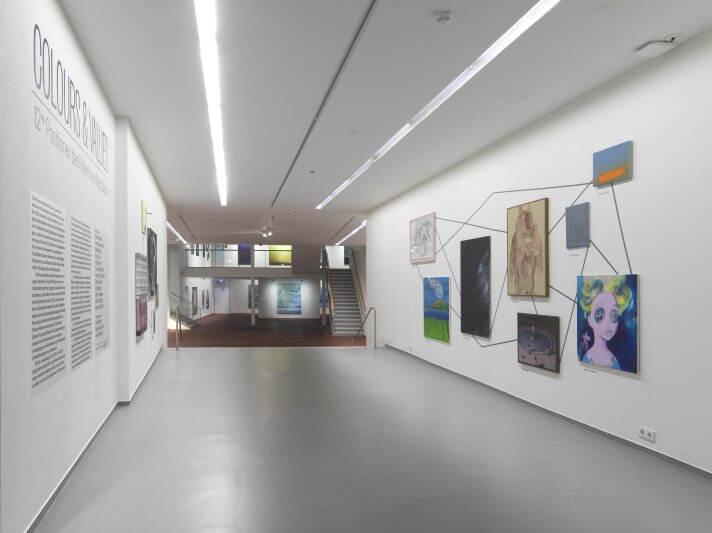 Blick in die Ausstellung „Colours & Values. 12+ Positionen des MalerinnenNetzWerks“ Ein offener heller Raum mit verschiedenen Ebenen und Gemälden an der Wand