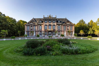 Blick auf ein Schloss mit einem bepflanzten Beet im Vordergrund