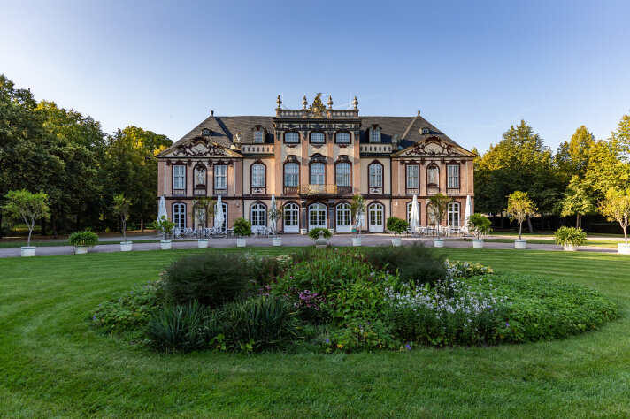 Blick auf ein Schloss mit einem bepflanzten Beet im Vordergrund