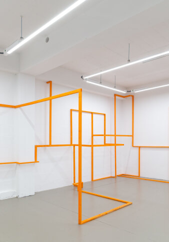 Orange Streben zu Kunstwerk in weißem Raum zusammengefügt