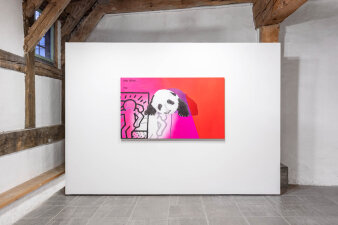 Blick auf eine weiße Wand mit rot pinkem Gemälde mit einem Pandabär