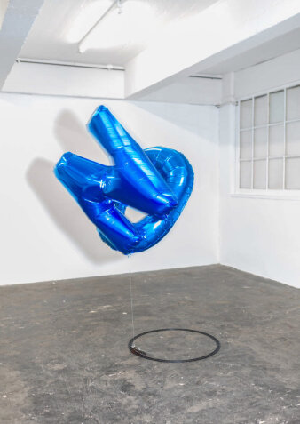 Zwei blaue Luftballons an einer Modelleisenbahn in einem hellen Raum