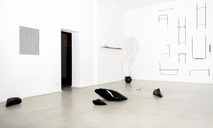 Heller Raum mit verschiedenen schwarz-weißen Kunstwerken an den Wänden und auf dem Boden