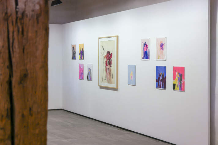 Blick in einen hellen Raum mit bunten Kunstwerken an der Wand